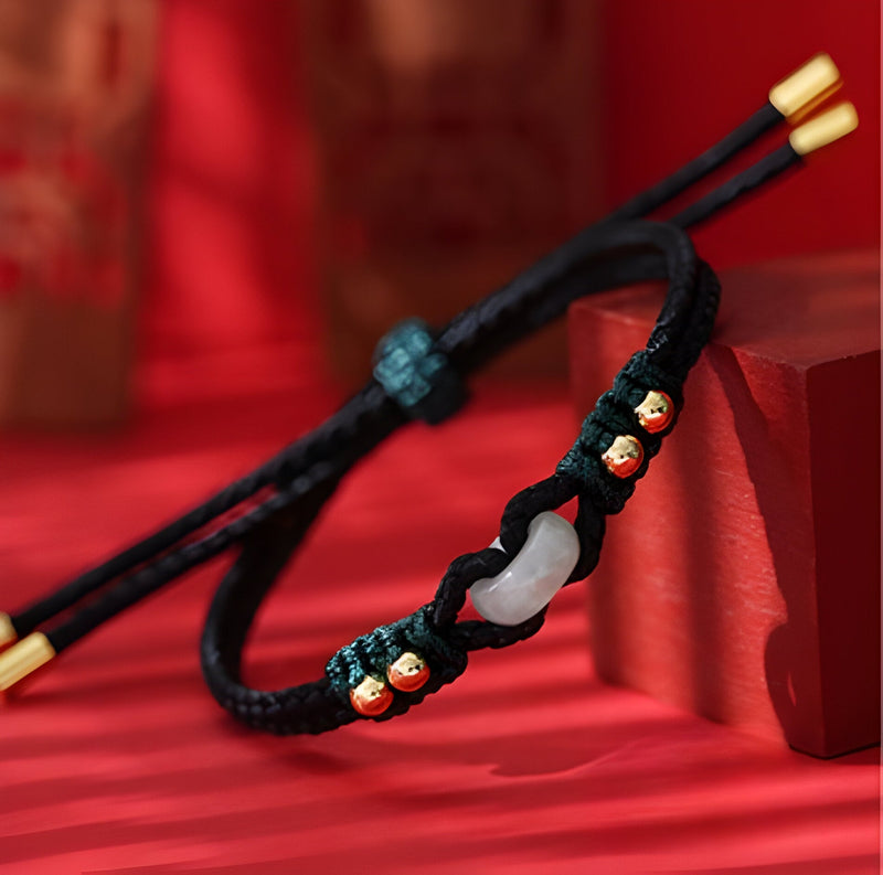 Bracelet en corde noire tressée avec pierre de jade blanche et perles dorées, style mixte.