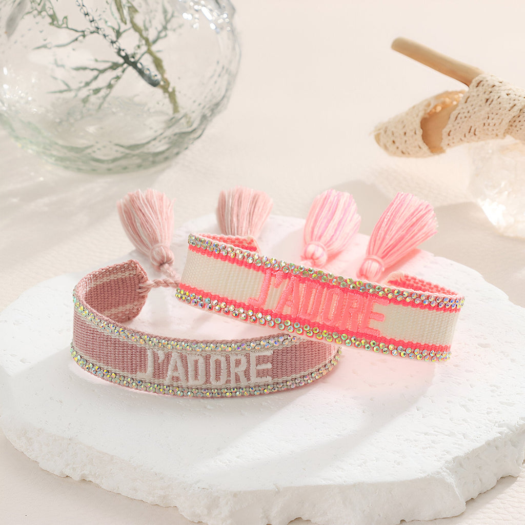 Bracelet en corde tressée rose clair avec inscription "J'ADORE" et pompons assortis, style Teresa.