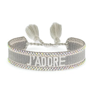 Bracelet en corde tressée gris avec inscription "J'ADORE" en blanc et bordure multicolore scintillante.