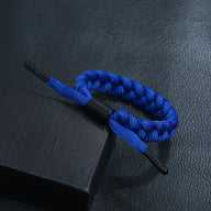 Bracelet en corde tressée bleu vif avec embouts noirs, style simple et moderne.