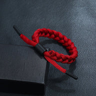 Bracelet tressé en corde rouge avec embouts noirs, style simple et élégant.