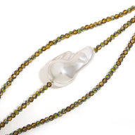 Bracelet fin avec perles kaki brillantes et grande perle centrale irrégulière blanche nacrée.