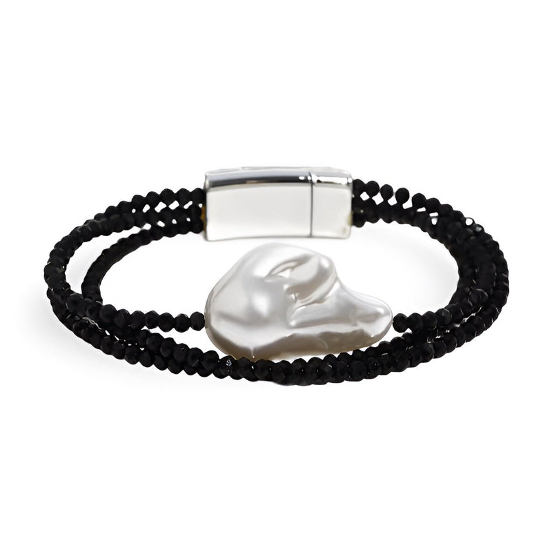 Bracelet noir à double rang de perles fines avec grande perle centrale irrégulière blanche brillante et fermoir magnétique.