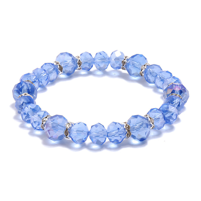 Bracelet élastique bleu en perles de cristal facettées avec petits anneaux argentés entre chaque perle.