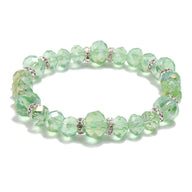 Bracelet en cristal vert pâle transparent avec perles facettées et petits anneaux argentés entre chaque perle.