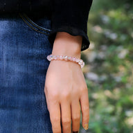 Bracelet en cristal rose clair en perles facettées porté au poignet féminin.