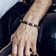 Bracelet homme en titane avec pierres vertes et cristaux scintillants sur poignet.