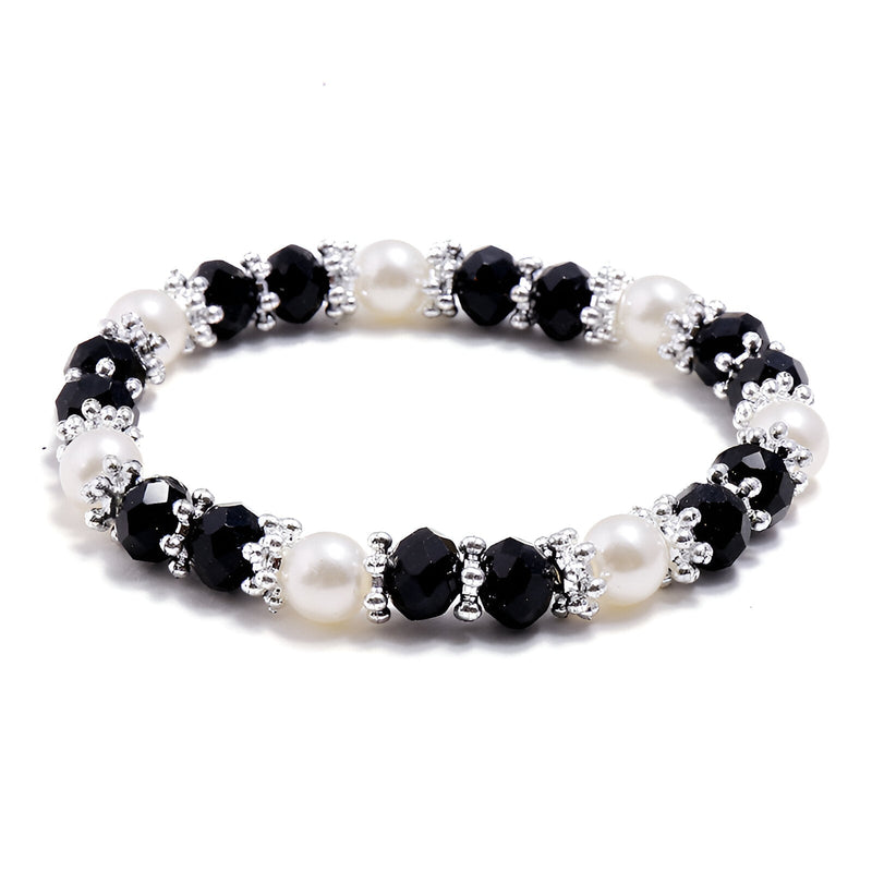 Bracelet élégant pour femme en perles noires facettées et perles blanches lisses, avec petits anneaux argentés entre les.