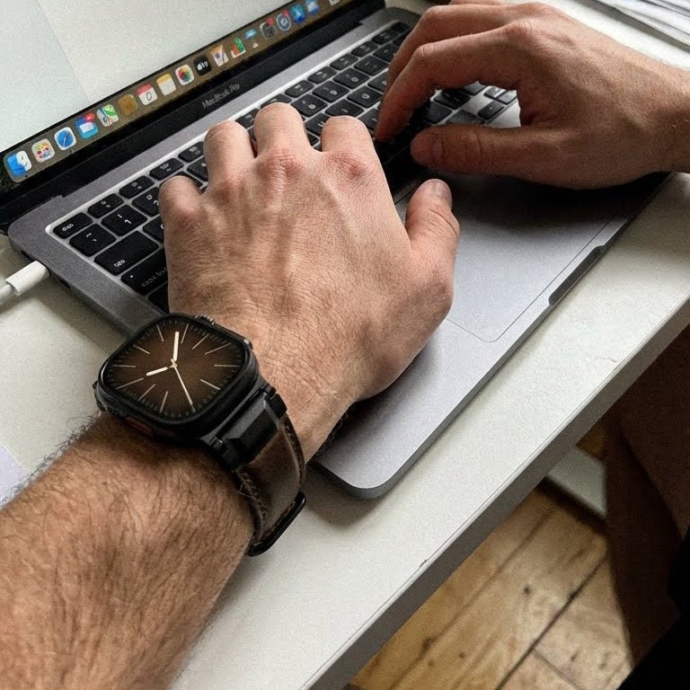 Bracelet en cuir noir texturé, style moderne et technique, ajustable, porté sur Apple Watch noire.