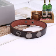 Bracelet homme en cuir marron avec fermeture à boutons pression métalliques.