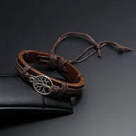 Bracelet en cuir marron avec pendentif arbre de vie en métal argenté et lacets ajustables.