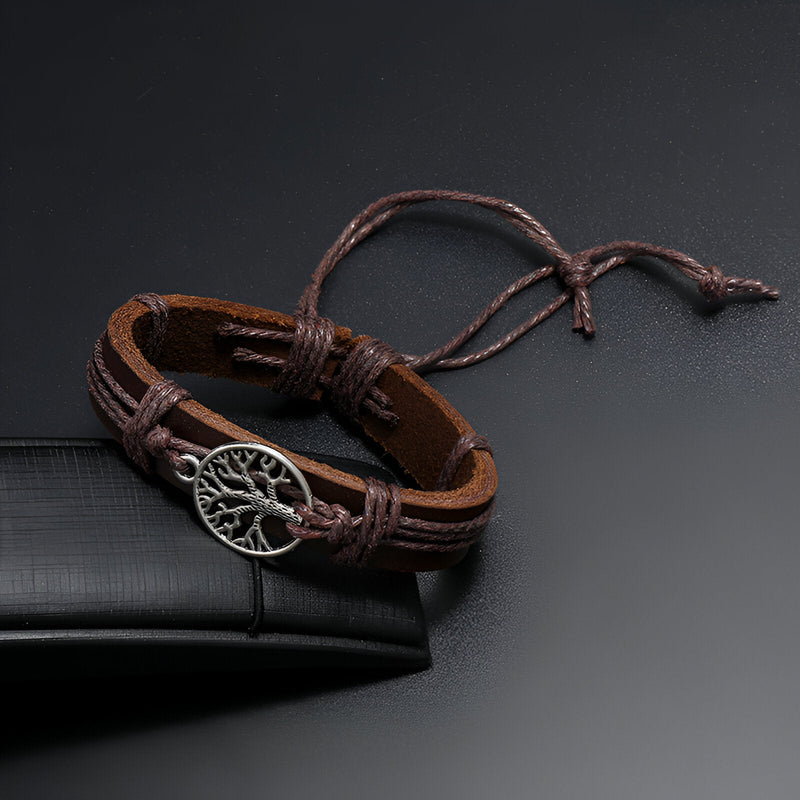 Bracelet en cuir marron avec pendentif arbre de vie en métal argenté et lacets ajustables.