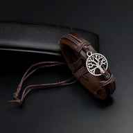 Bracelet en cuir marron avec médaille arbre de vie en métal argenté et cordons réglables.