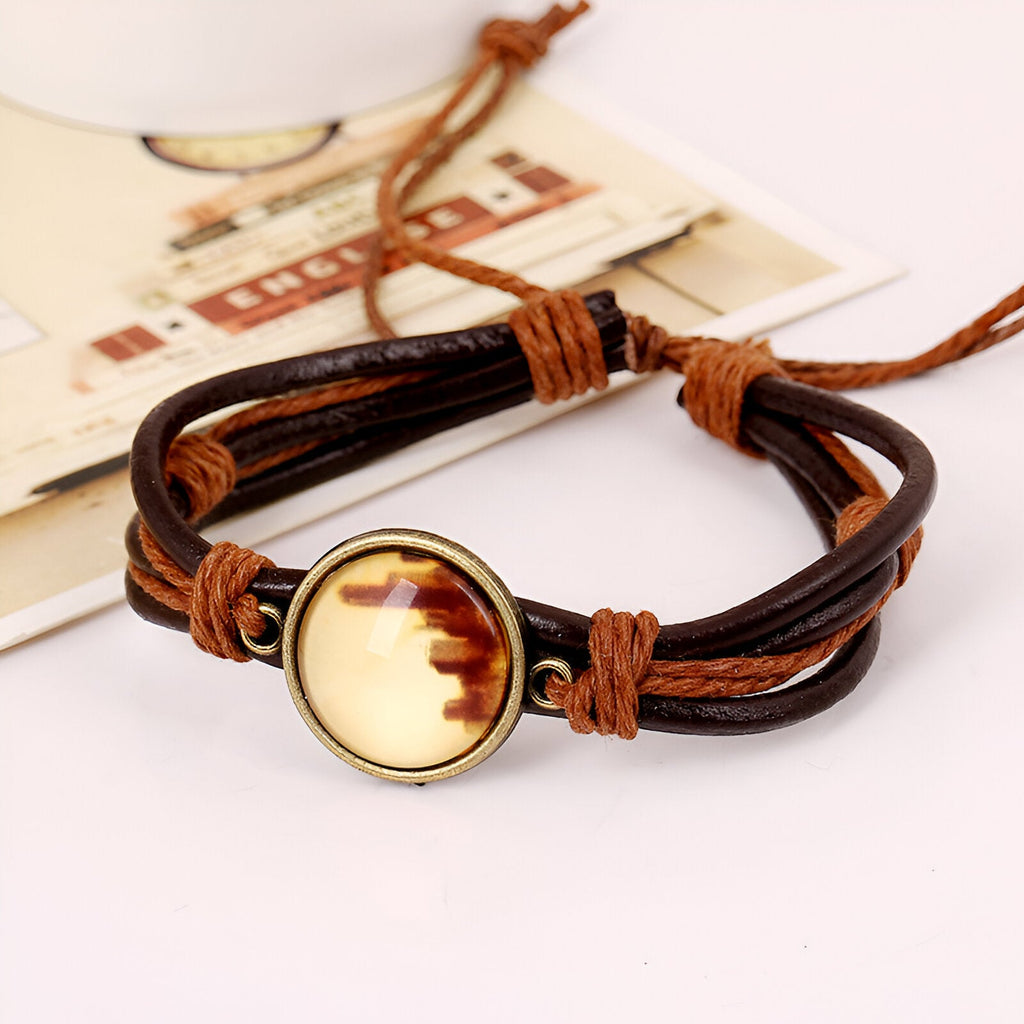 Bracelet en cuir marron et noir avec médaillon doré, style unisexe ajustable.