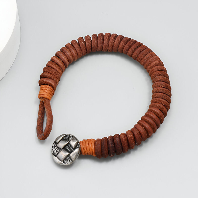 Bracelet en cuir marron torsadé avec boucle métallique argentée, style masculin élégant.