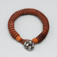 Bracelet homme en cuir marron tressé avec fermoir métallique argenté effet croisé.
