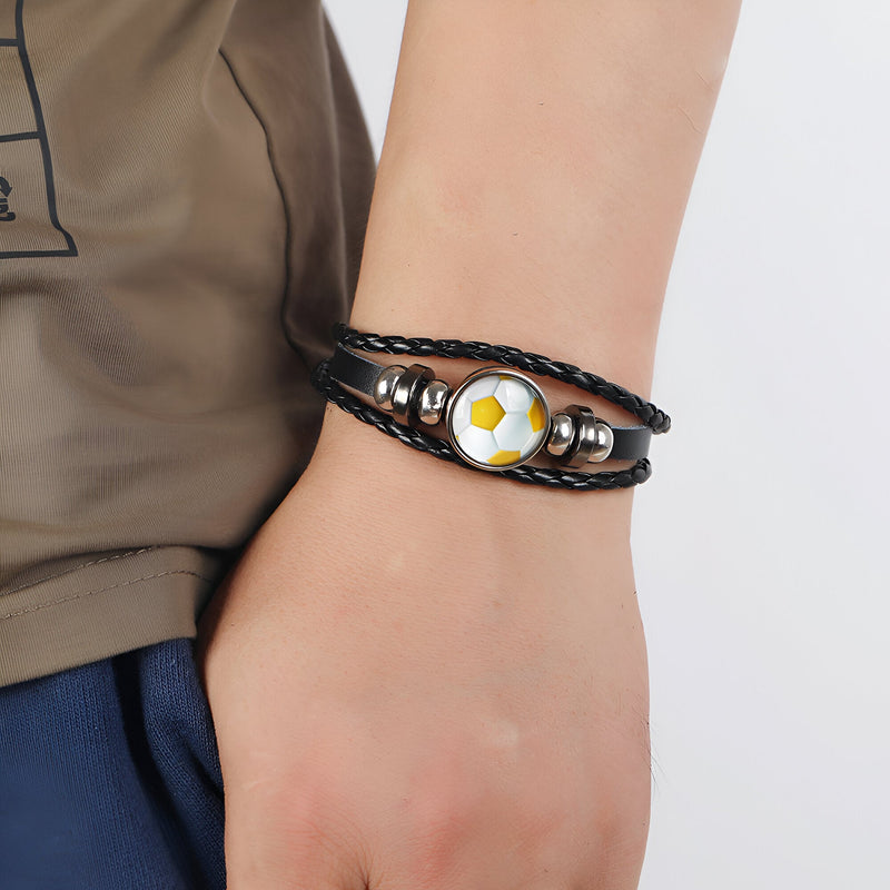 Bracelet en cuir noir multi-brins avec perles argentées et breloque ballon de football jaune et blanc.