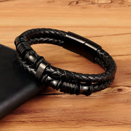 Bracelet en cuir noir tressé avec détails en acier noir et fermoir magnétique élégant.