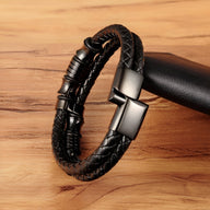 Bracelet noir en cuir tressé avec fermoir en acier noir mat, style masculin et moderne.