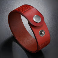 Bracelet en cuir marron avec motifs gaufrés et fermoir à bouton-pression métal argenté.