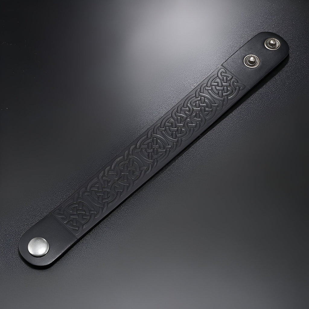 Bracelet en cuir noir pour homme avec motifs gaufrés et fermoir à pression métallique argenté.