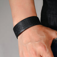 Bracelet cuir noir masculin avec motifs gaufrés entrelacés, style moderne et élégant.