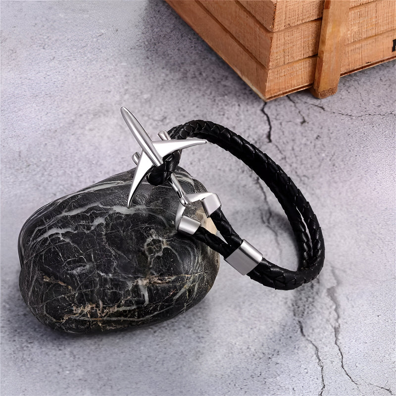 Bracelet noir en cuir tressé avec avion en acier inoxydable brillant et fermoir élégant.