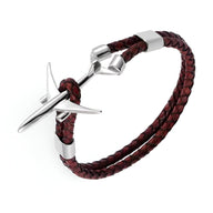 Bracelet en cuir marron tressé avec avion en acier inoxydable brillant et fermoir métallique.