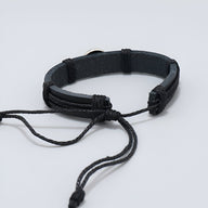 Bracelet noir en cuir tressé avec fermeture ajustable, style sportif masculin.
