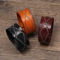 Bracelet en cuir clouté orange style western avec motif croisé d'anneaux métalliques.