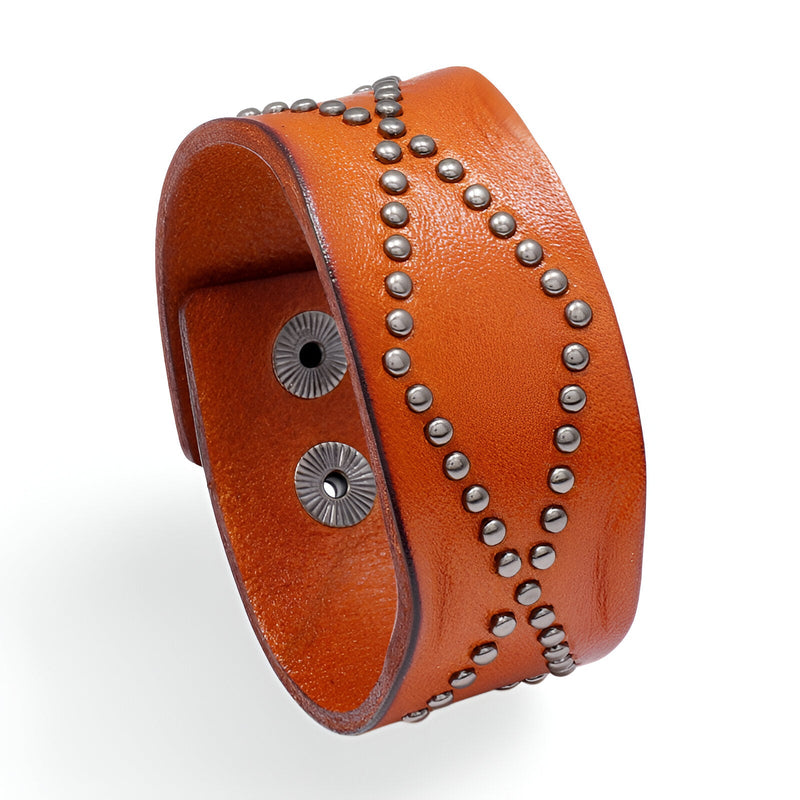 Bracelet large en cuir orange clouté de petits rivets métalliques formant un motif croisé vintage.