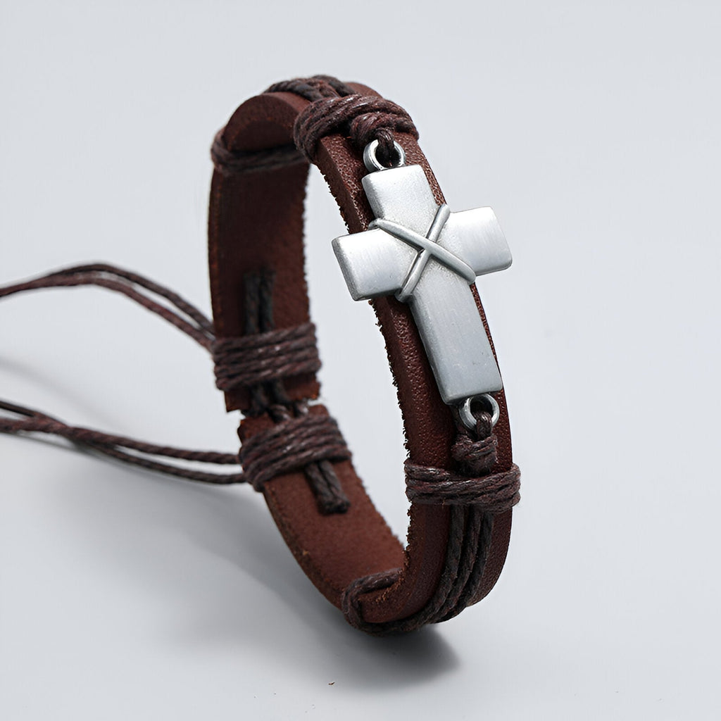 Bracelet homme en cuir marron avec croix chrétienne en métal argenté et cordons tressés.