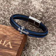 Bracelet homme en cuir bleu tressé avec croix chrétienne argentée et fermoir magnétique acier.