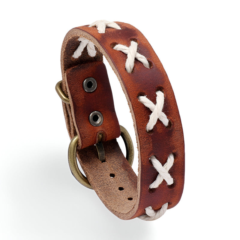 Bracelet en cuir marron avec croix tressées blanches et boucle métallique antique.