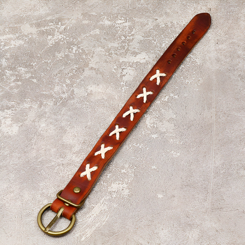 Bracelet en cuir marron avec croix blanches tressées et boucle métal doré.