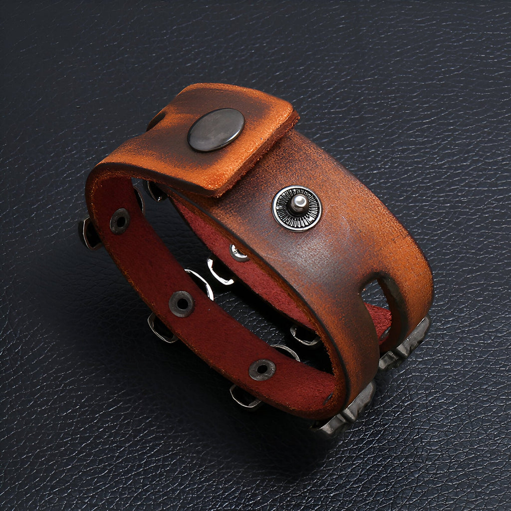 Bracelet en cuir marron double tour avec motifs têtes de mort et fermoir à pression métal noir.