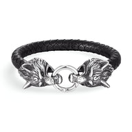 Bracelet en cuir noir tressé avec double tête de loup en métal argenté et fermeture anneau.
