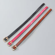 Trois bracelets en cuir fins pour femme, couleurs marron, rose vif et noir, boucles dorées élégantes.