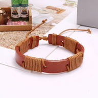 Bracelet en cuir marron entrelacé de fils beige avec fermeture coulissante ajustable.