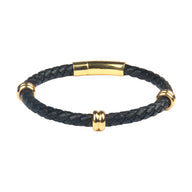 Bracelet en cuir noir tressé avec détails métalliques dorés et fermoir aimanté.