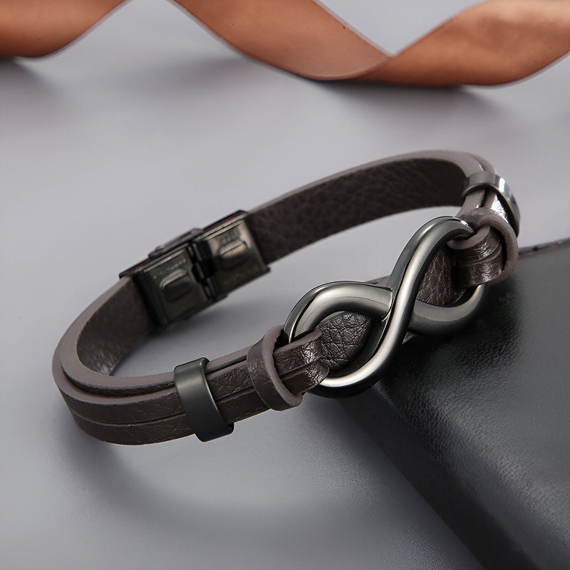 Bracelet homme en cuir marron avec motif infini en acier inoxydable noir mat et fermoir à clip.