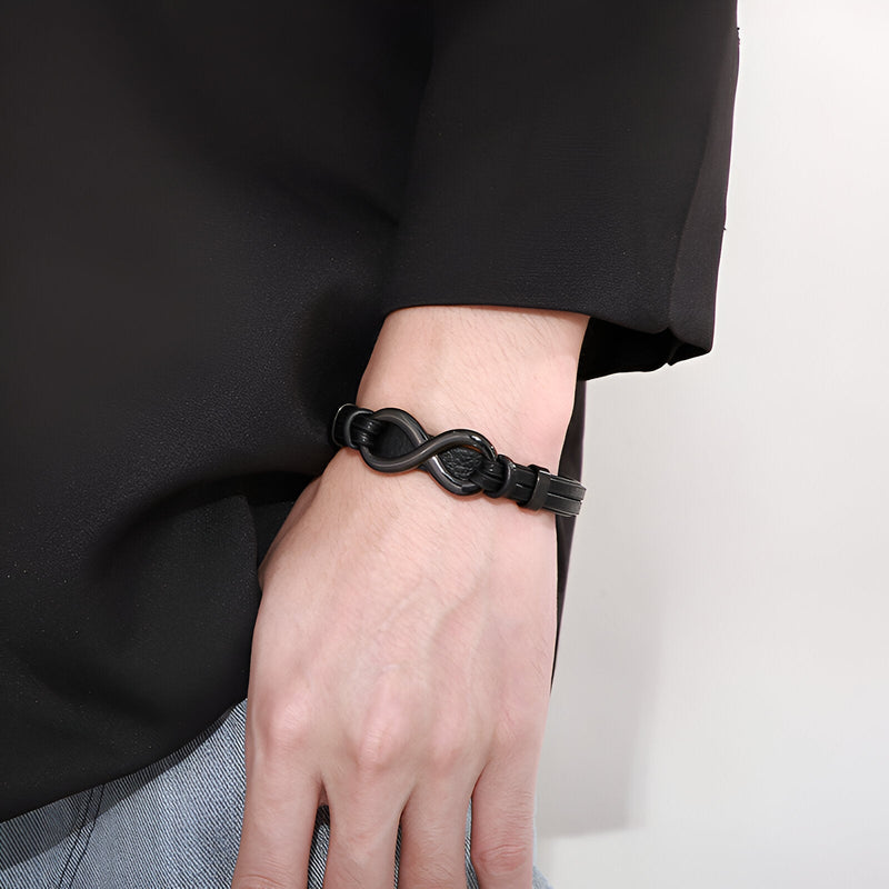 Bracelet noir en cuir avec motif infini en acier inoxydable, modèle Betis, porté au poignet.