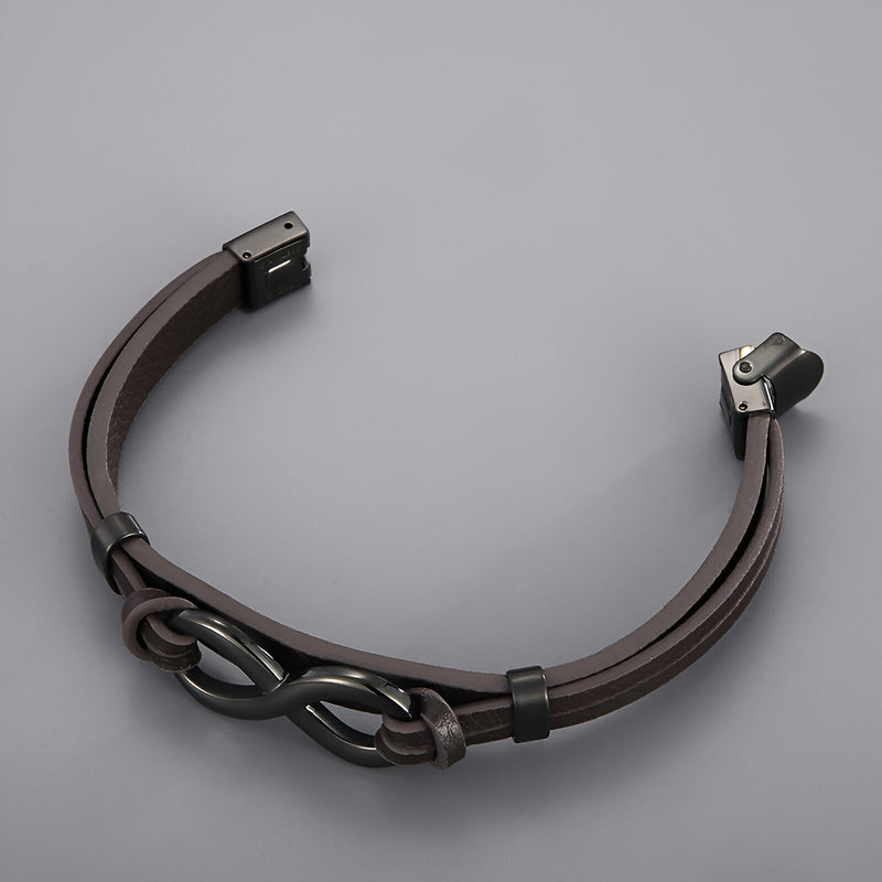 Bracelet en cuir marron avec motif infini en acier inoxydable et fermoir noir élégant.