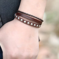 Bracelet mixte marron en cuir et microfibre avec rivets métalliques et tresse noire.