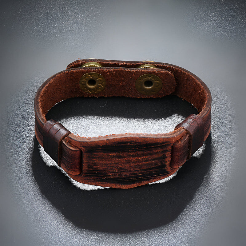 Bracelet large en cuir marron vieilli avec boutonnières en métal doré, style vintage masculin.