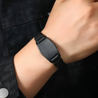 Bracelet large en cuir noir à bouton pression, style masculin et moderne.