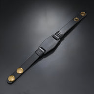 Bracelet en cuir noir large avec fermeture à boutons pression dorés pour homme.