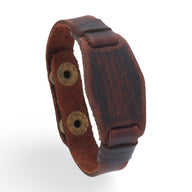 Bracelet large en cuir marron avec couture détaillée et fermeture à bouton pression double.