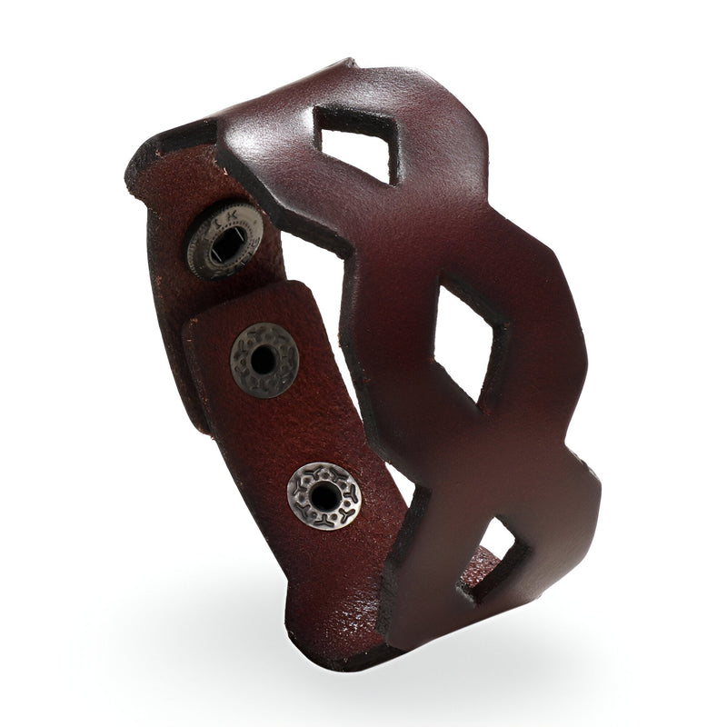 Bracelet large en cuir café avec formes géométriques découpées et fermoir à boutons-pression métalliques.