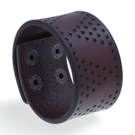 Bracelet manchette large en cuir café avec motifs à trous ronds et fermetures pression noires.